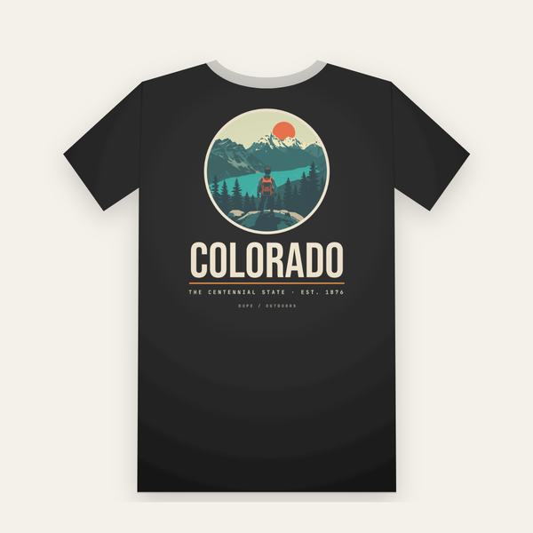 Black tee, back print: a hiker above a turquoise lake and snowy peaks in a circle, COLORADO below