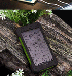 SunCache solar power bank beaded with rain on a wet log