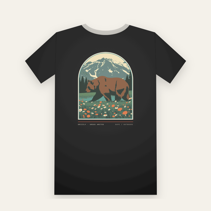 Black tee, back print: a grizzly bear in a wildflower meadow under a snowy peak, inside a large arch