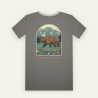 Charcoal tee, back print: a grizzly bear in a wildflower meadow under a snowy peak, inside a large arch